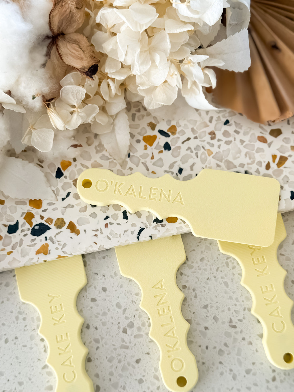 Cake Key™ resting on the edge of a cake board, ready to slide underneath and lift