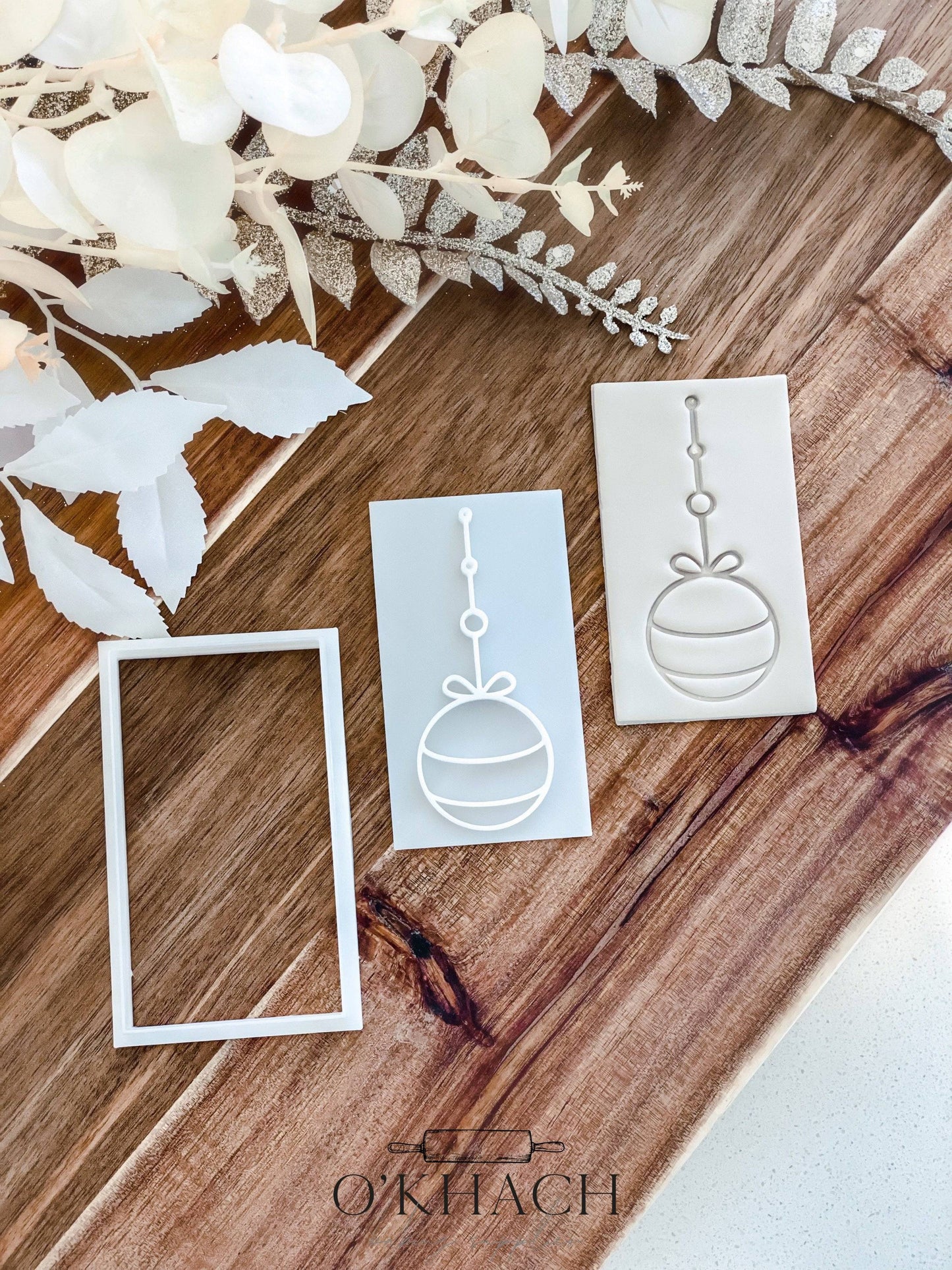 Bow Bauble Christmas cookie stamp and cutter by O'Khach, shown stamped in fondant